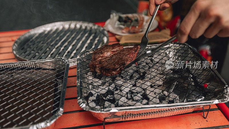 BBQ party，户外烧烤活动。火与肉摄影。在木炭烤架上烤肉片，烧烤牛排的特写照片